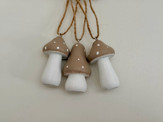 Three mushroom-shaped decorations hanging on a string