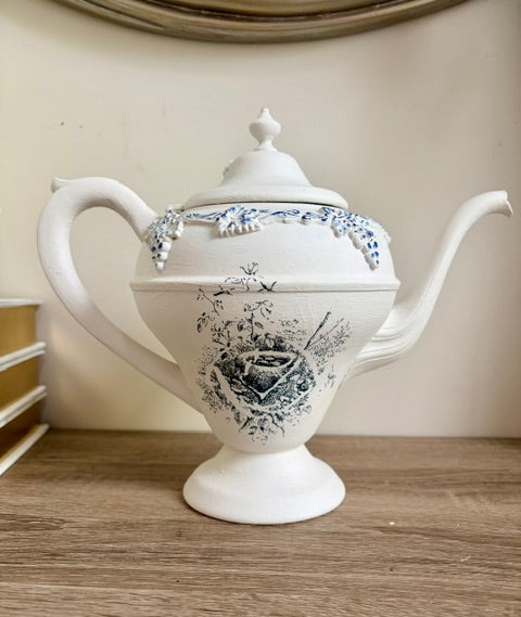 Painted white teapot with blue nest image and white faux florals
