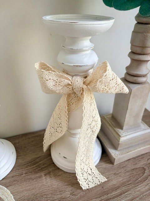 White candlestick with lace bow.
