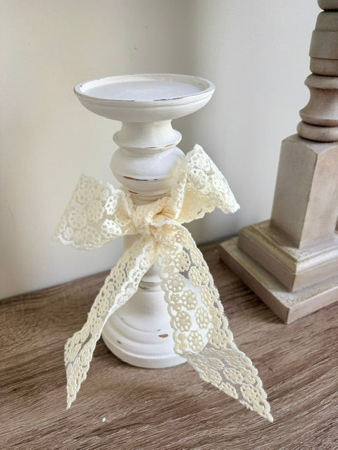 White candlestick with lace bow.