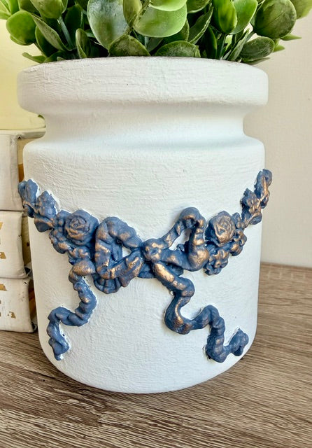 Blue and gold bow on vase.
