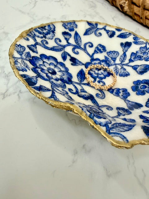 Gold trimmed trinket dish with a blue floral pattern.