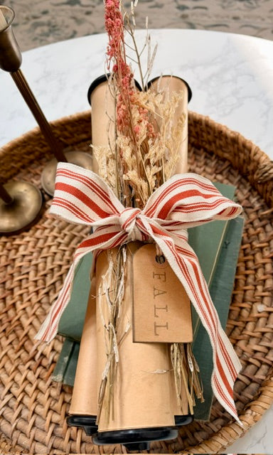 Bundle of three piano rolls with dried florals, fabric bow and "fall" tag.