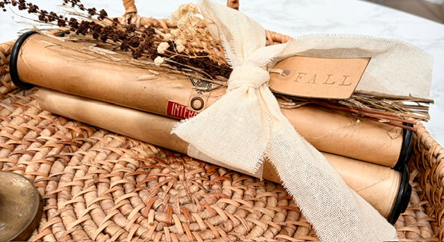 Bundle of three piano rolls with dried florals, fabric bow and "fall" tag.