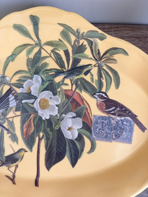 Floral and bird image on a yellow ceramic plate.