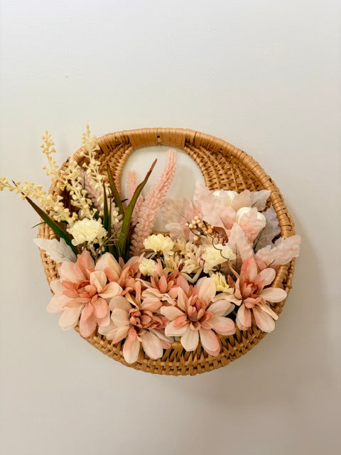 Circular wicker wall basket with fall florals in cream and blush tones.