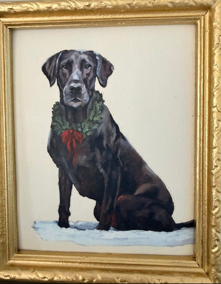 A framed portrait painting of a black dog wearing a green holiday wreath with a red bow, set against a light background. The artwork is enclosed in an ornate gold frame.