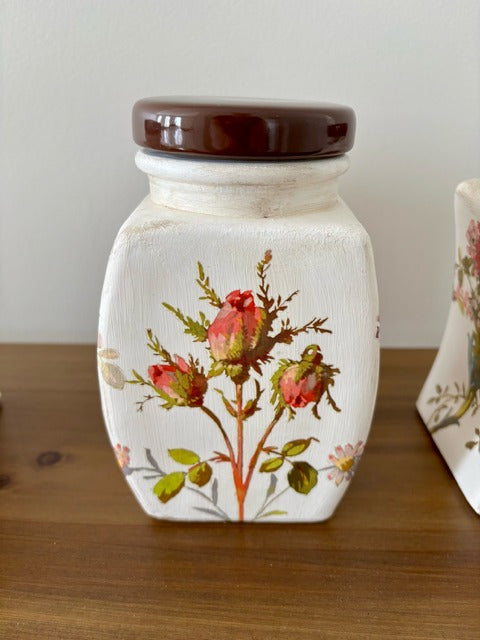 Decorative ceramic jar with floral design on a wooden surface