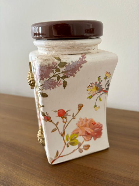 Decorative ceramic jar with floral design on a wooden surface