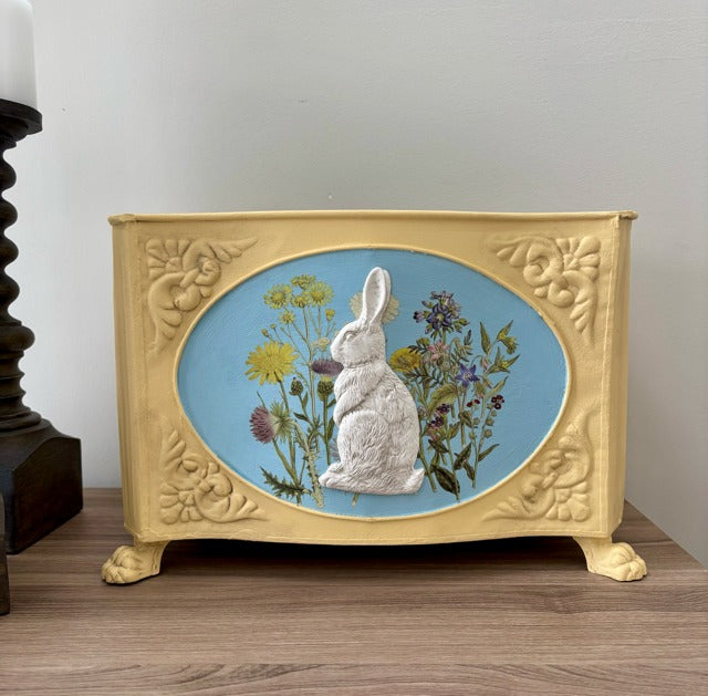 Decorative box with a rabbit and floral design on a blue background