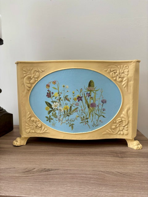 Decorative box with a floral design on a blue background