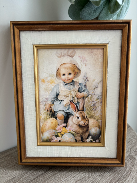 Framed artwork of a child and rabbit on a textured surface