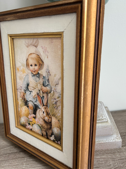 Framed artwork of a child and rabbit on a textured surface