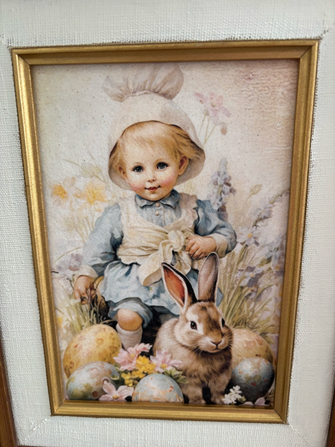 Framed artwork of a child and rabbit on a textured surface