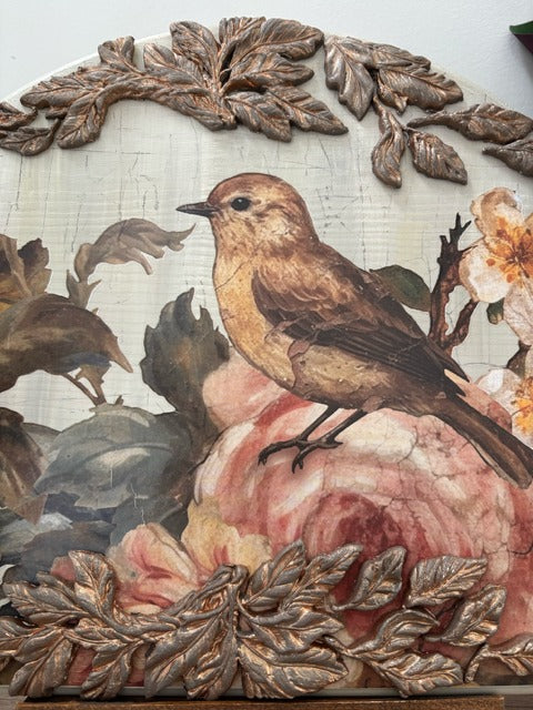 Decorative panel with a bird and floral design, framed by leaf patterns.