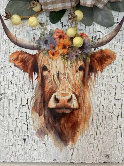 Painting of a cow with floral headpiece on a textured white background