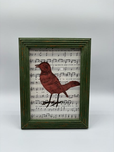 Green wood frame with bird painted on music sheet
