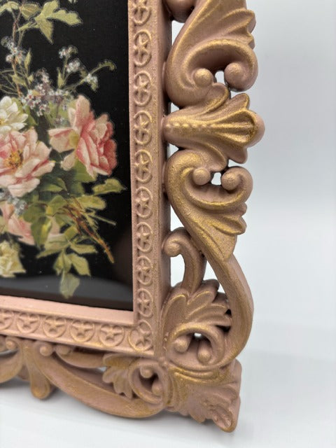 Decorative pink frame with floral design on a black background