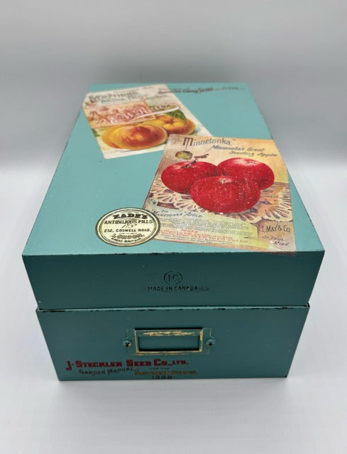 Teal vintage-style box with printed labels on a white background