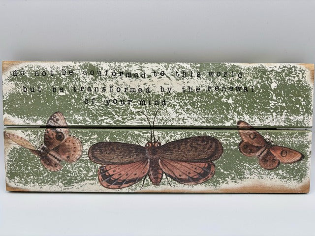 Decorative wooden panel with butterfly illustrations and text on a light gray background