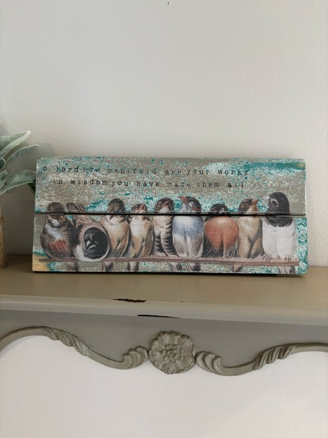 Decorative wooden plaque with bird illustrations on a shelf