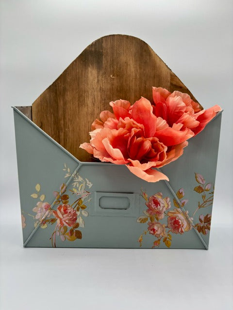 Floral-patterned box with a wooden lid containing coral flowers on a white background