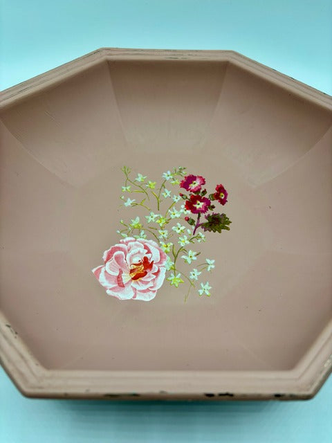 Decorative dish with floral design on a light blue background