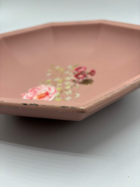 Pink decorative dish with floral design on a white background