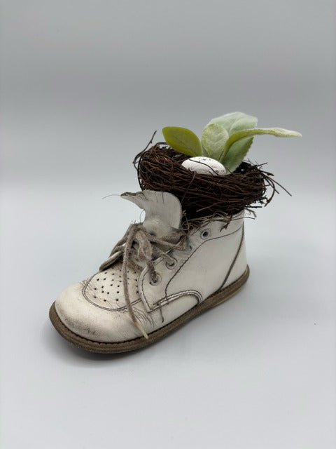 White baby shoe with a nest and eggs 