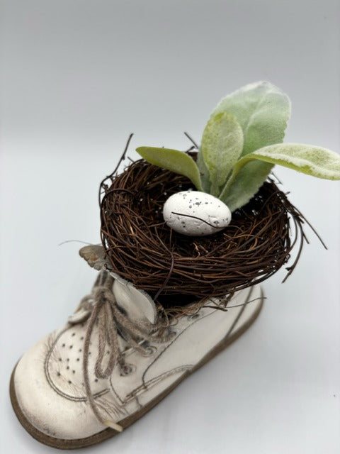 White baby shoe with a nest and eggs 