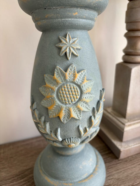 Decorative candle holder with floral design on a wooden surface