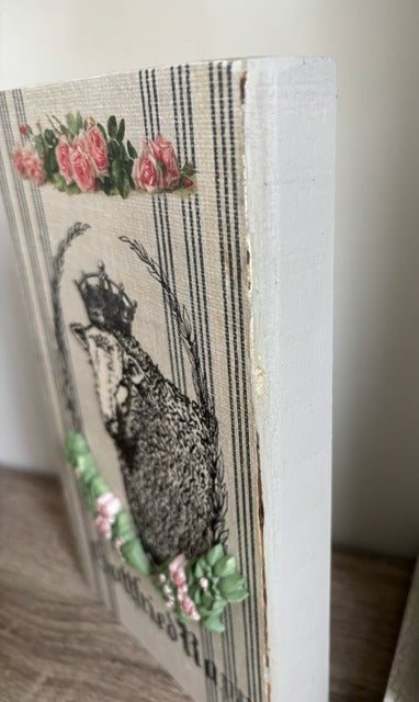 Decorative wood panel with a sheep and floral design 