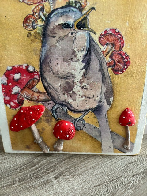 Decorative wood panel with a bird and mushroom design 