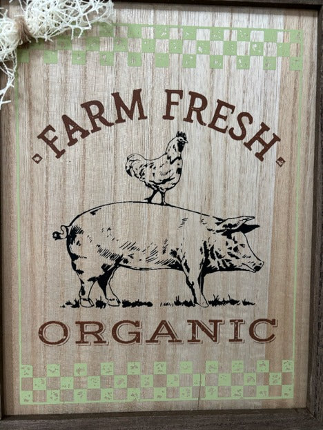 Decorative sign with 'Farm Fresh Organic' text and illustrations of a pig and chicken on a rustic background.