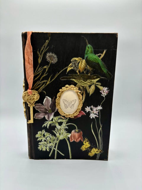 Decorative book with floral and bird illustrations on a black background