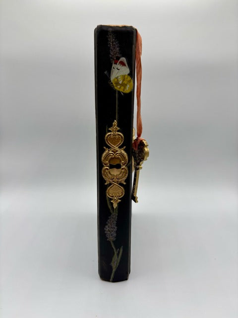 Decorative book with gold accents and floral design on a white background