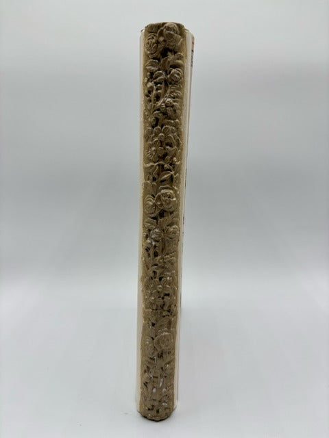 Long, thin book spine with engraved patterns on a white background