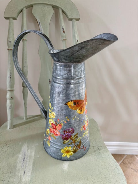 Decorative metal pitcher with floral design 