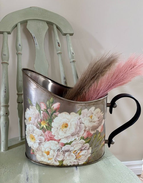 Decorative metal pitcher with floral design and pink faux pampas grass