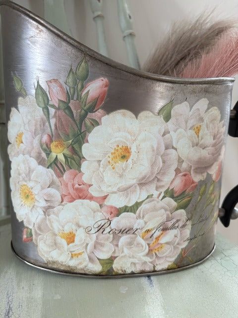 Decorative metal pitcher with floral design and pink faux pampas grass