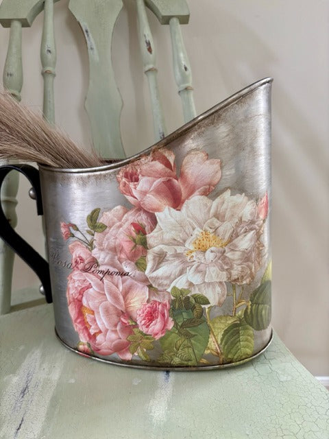 Decorative metal pitcher with floral design and pink faux pampas grass