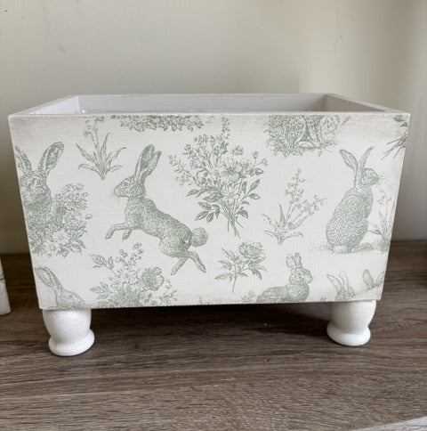Decorative box with rabbit design and gold keyhole.
