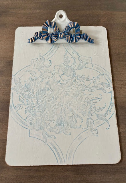 Decorative clipboard with floral design on a wooden surface