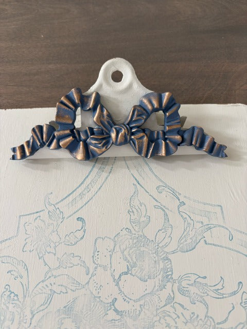 Decorative bow on a clipboard 
with a patterned fabric background