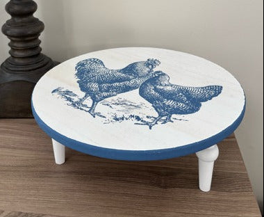 Round riser with blue and white design on a wooden surface