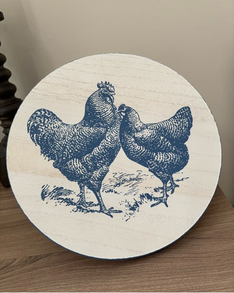 Round wooden riser with blue chicken design on a wooden surface