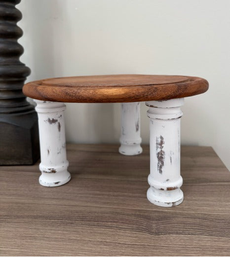 Wooden riser with white distressed legs on a wooden surface