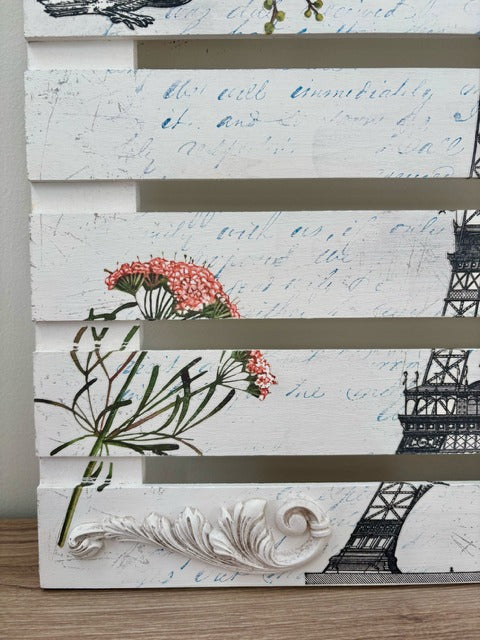 Wooden panel with floral and architectural designs on a white background