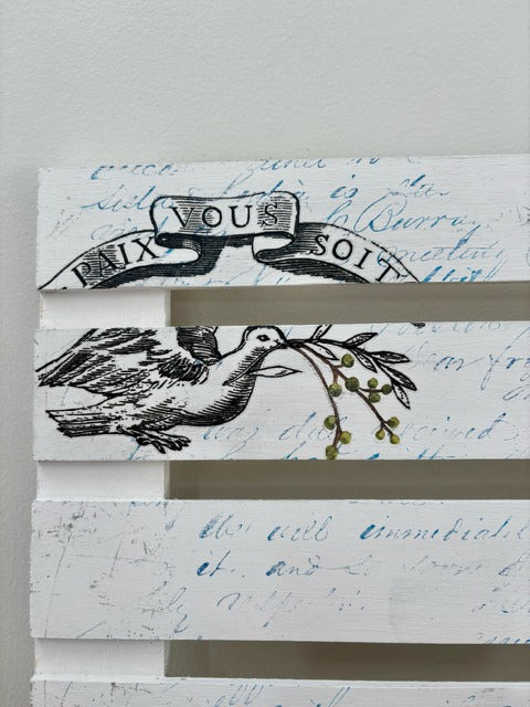 Decorative wood panel with text and bird design on a white background