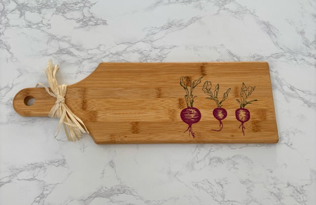 Bamboo cutting board with radish design on a marble surface
